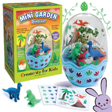 Mini Garden Dinosaur toy kit: a blue planter dome with tiny dinosaurs, plants, and decorative pieces; colorful box shown in background.
