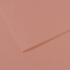 Close-up of light pink textured paper with a folded corner and layered edges.