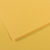 Two overlapping sheets of yellow textured paper on a yellow surface with soft shadows.