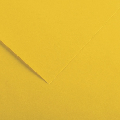 Close-up of yellow paper with a folded corner and soft shadow creating a diagonal line.
