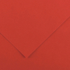 Close-up of red-orange paper with folded edges forming a diagonal V-shaped overlap.